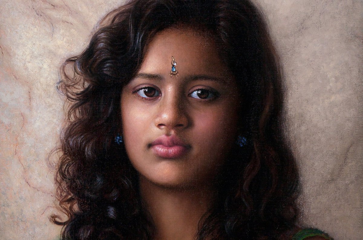Portrait of a young woman with dark curls and a forehead ornament